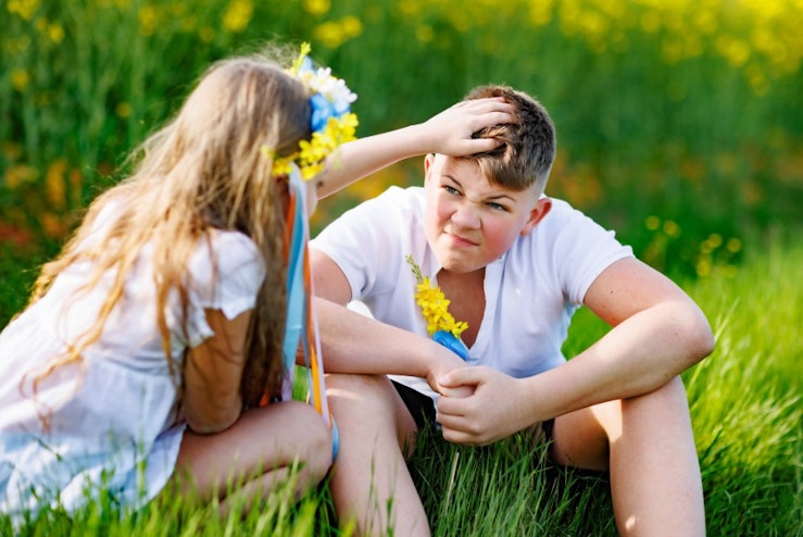 Teen boy and girl interacting with flowers