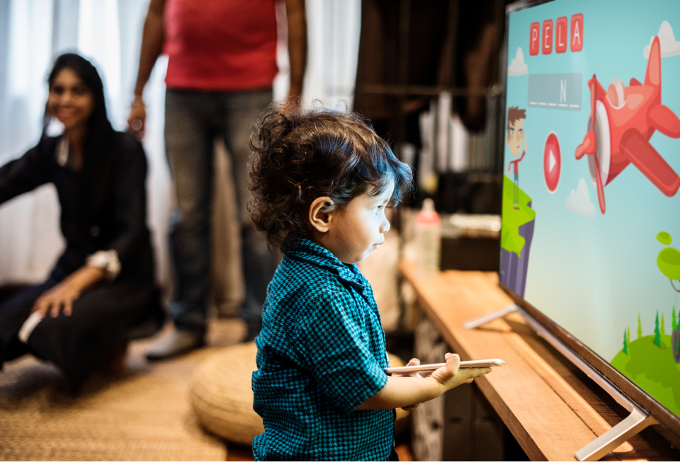 Young child standing in front of a TV screen